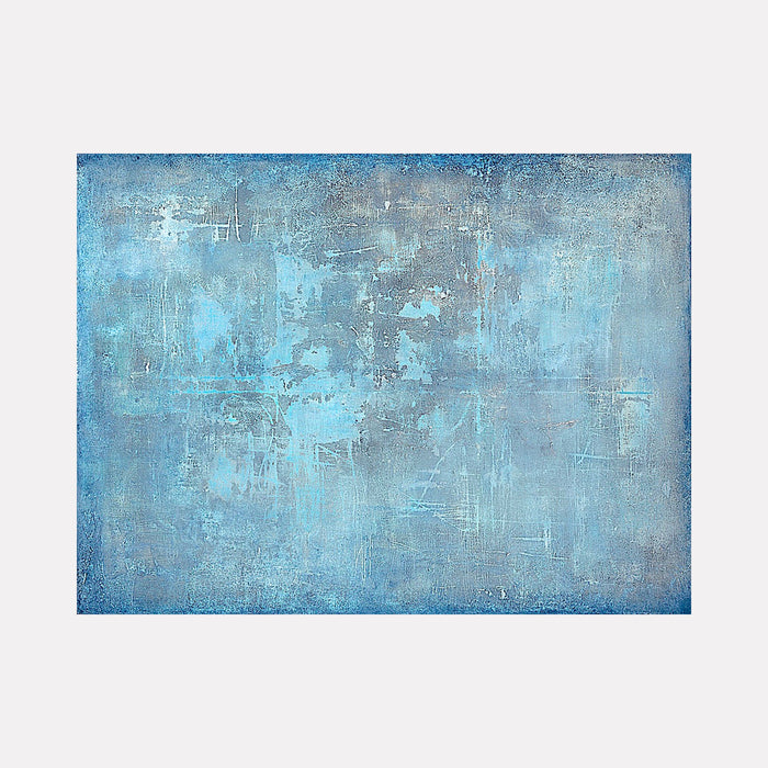 The artwork 'Reflection' by Nicole Hitchcock features a textured abstract composition in varying shades of blue and gray. The acrylic painting showcases a weathered, distressed surface with subtle scratches and layered techniques, creating a misty, ethereal atmosphere reminiscent of a clouded mirror or calm water surface. Measuring 48x36 inches, the piece demonstrates skillful blending and atmospheric depth.