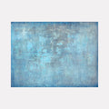 The artwork 'Reflection' by Nicole Hitchcock features a textured abstract composition in varying shades of blue and gray. The acrylic painting showcases a weathered, distressed surface with subtle scratches and layered techniques, creating a misty, ethereal atmosphere reminiscent of a clouded mirror or calm water surface. Measuring 48x36 inches, the piece demonstrates skillful blending and atmospheric depth.